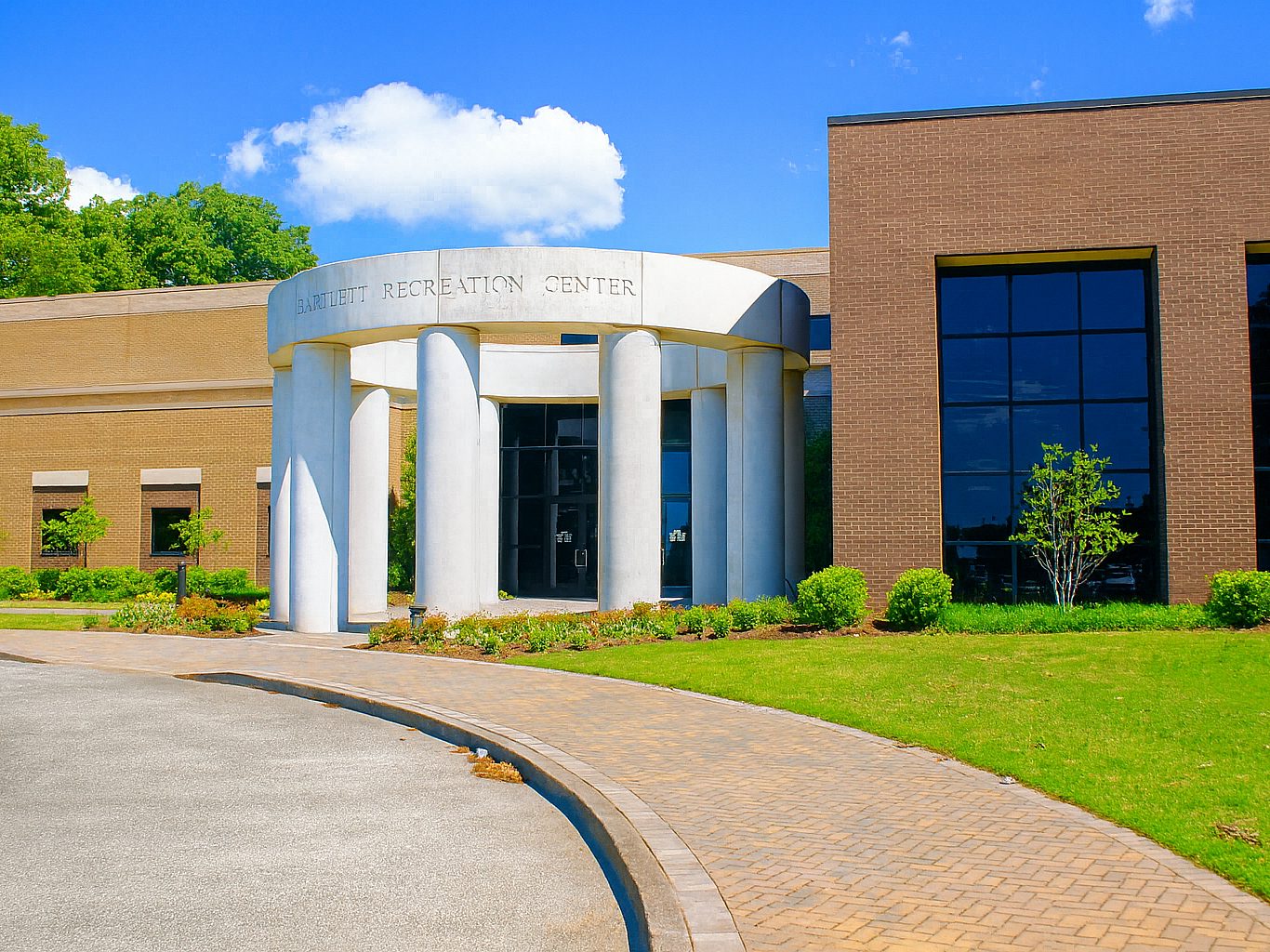 The entrance to a community rec center. A circular structure with columns supporting it is at the entrance with "Bartlett Recreation Center" written across the top.