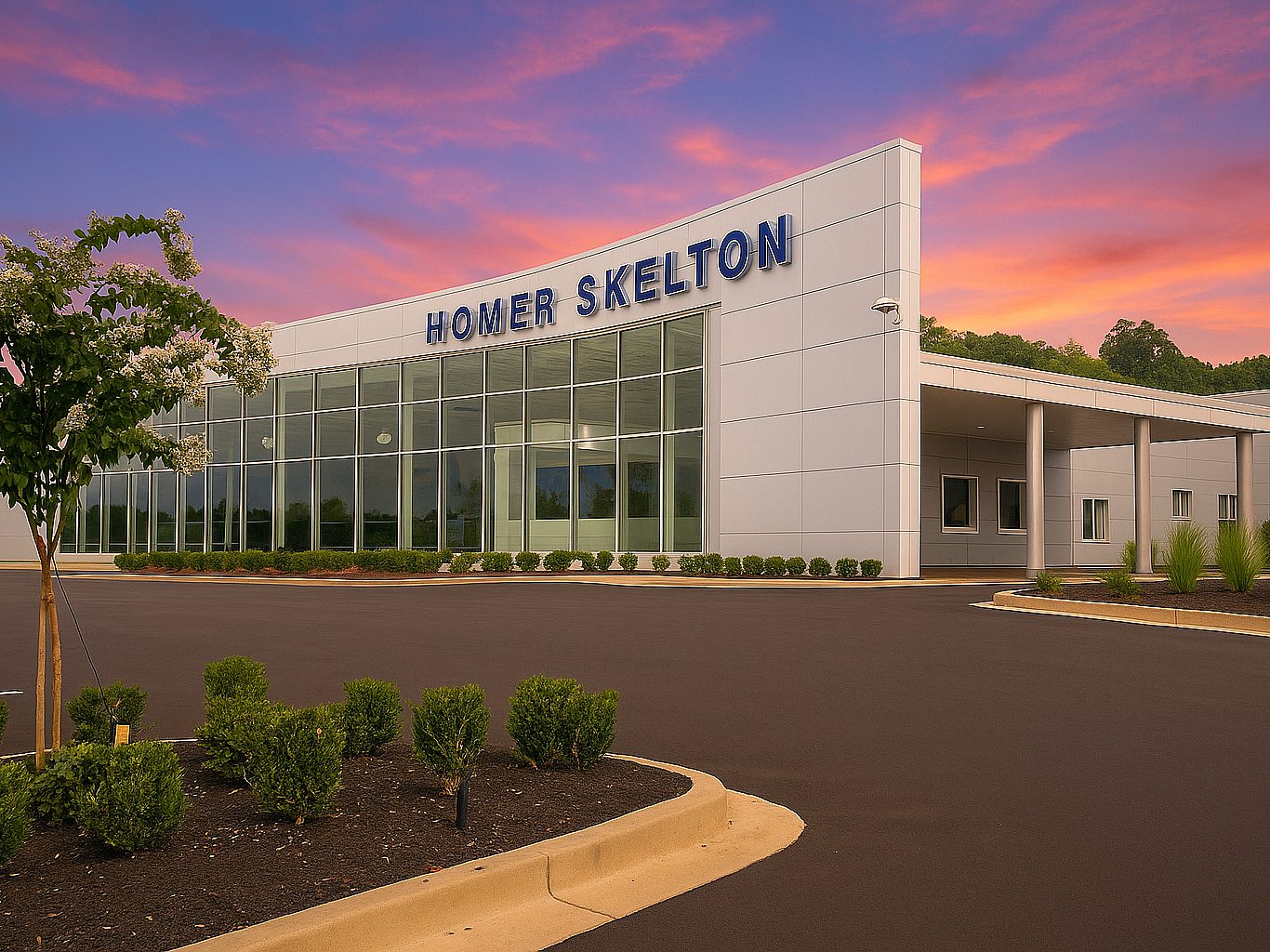Exterior view of a Ford dealership with Homer Skelton written at the top of the wall. Windows span one side of it.