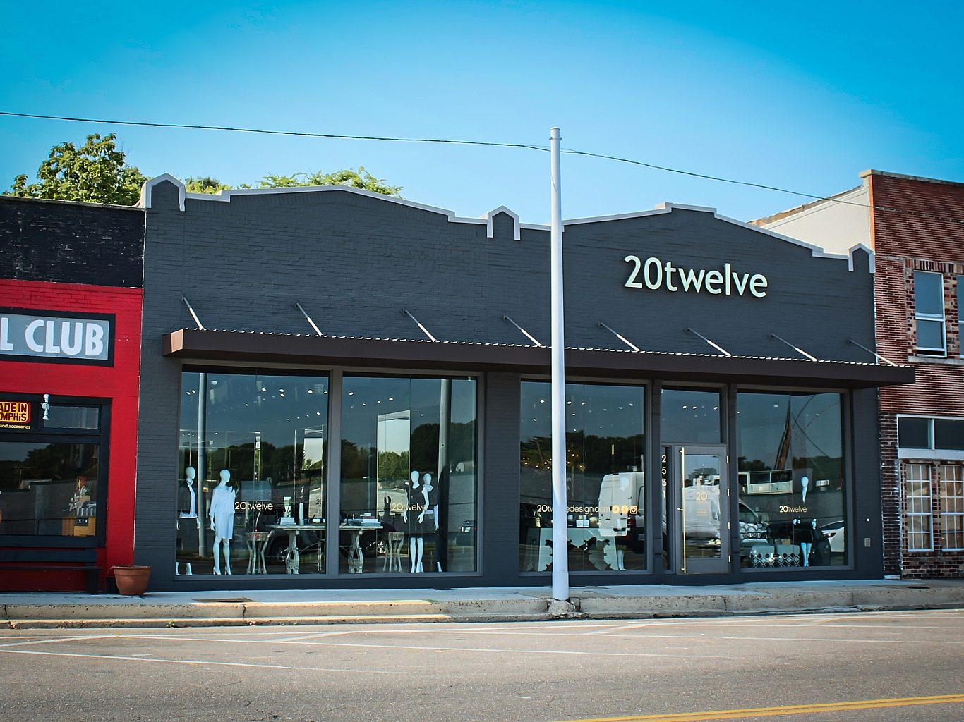 The exterior of a clothing store. Mannequins and retail items are on display in the window.