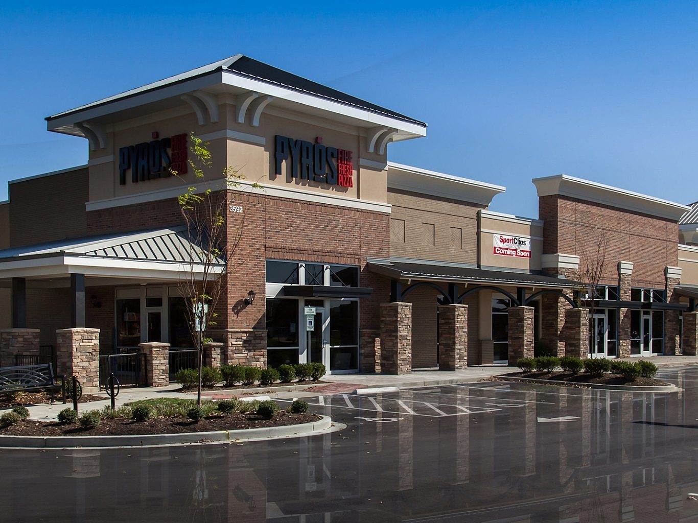 The exterior of a restaurant called Pyro's in a shopping center. The logo is above the main entrance and the parking lot is empty.