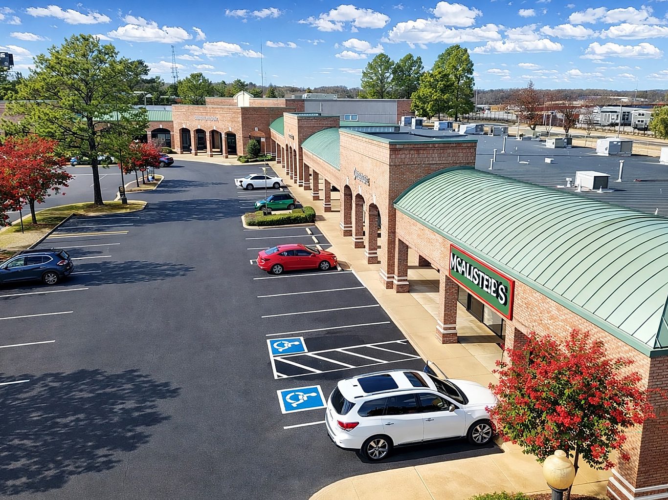 Aerial view of a shopping center and its parking lot.