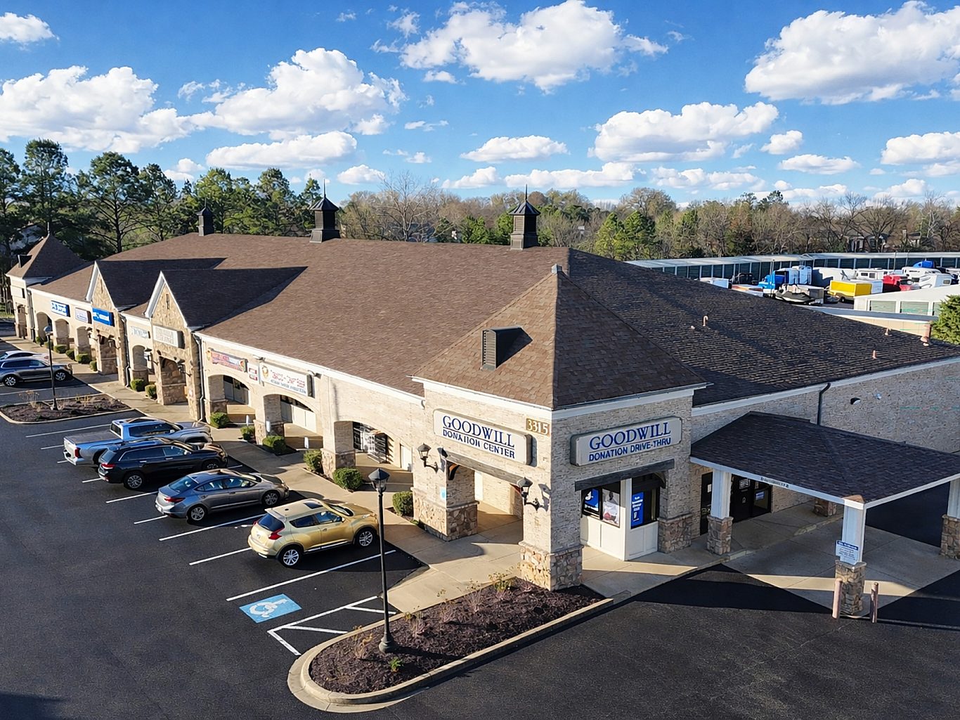 Aerial view of a shopping center with a drive through and cars in the parking lot