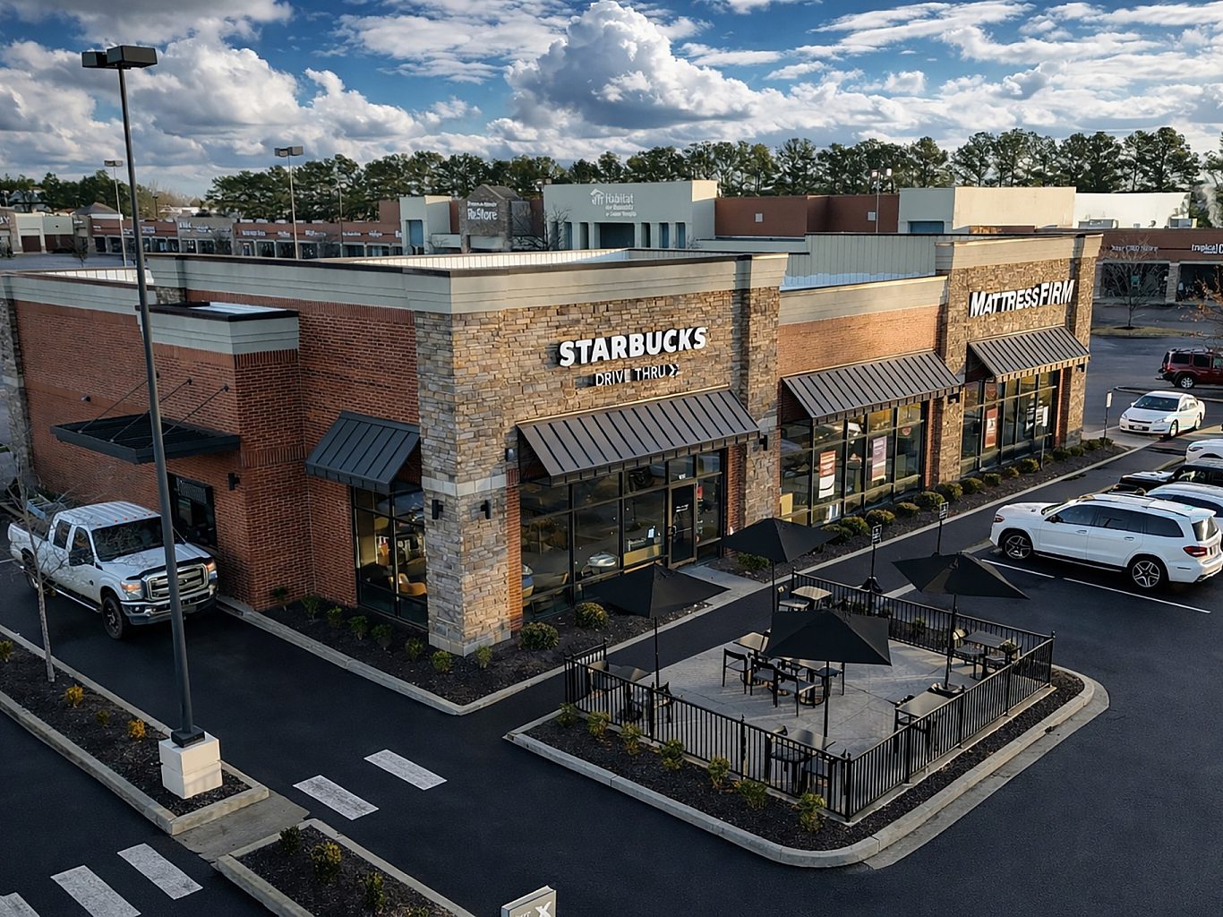 Aerial view of a three bay shopping center in Collierville, TN with a patio and drive through.