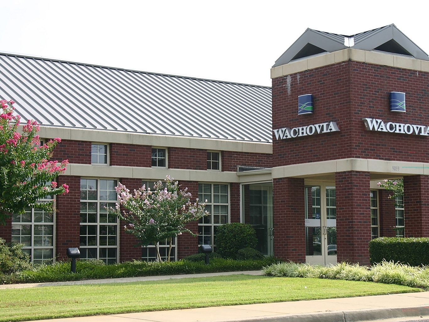 The exterior view of Wachovia Bank with a lawn and trees in front.