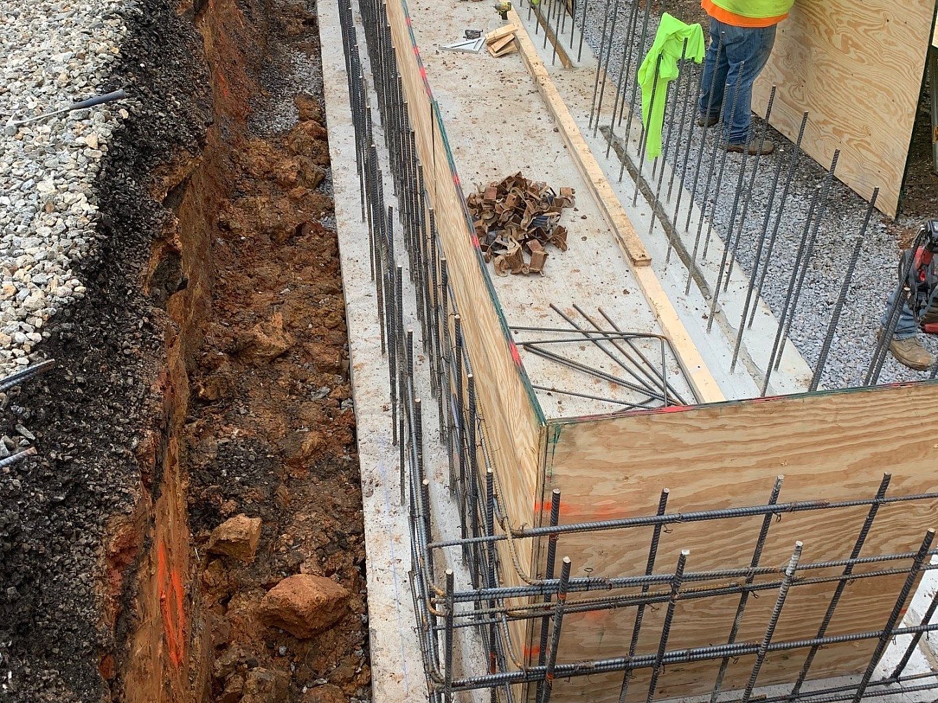 Construction worker installs plywood for a concrete foundation