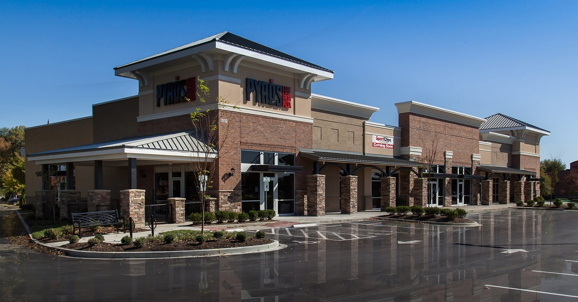 The exterior of a restaurant called Pyro's in a shopping center. The logo is above the main entrance and the parking lot is empty.