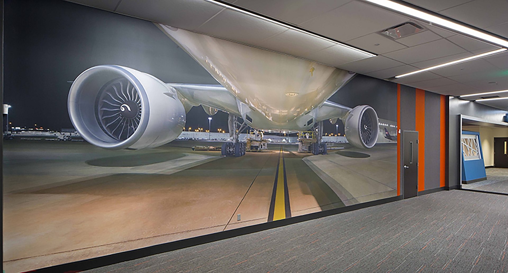 A floor to ceiling visual of a plane on the wall of an office.