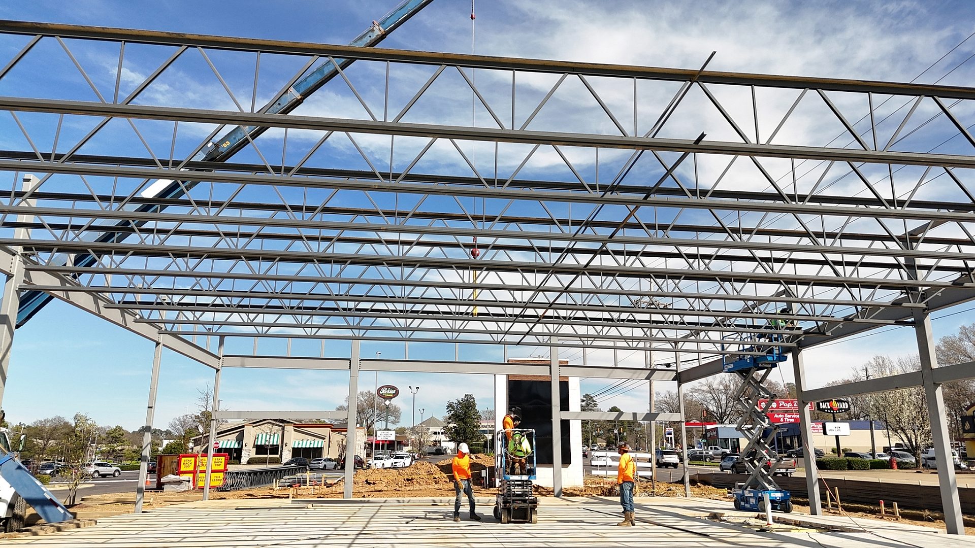 A construction site for a shopping center with construction workers in the middle of it.