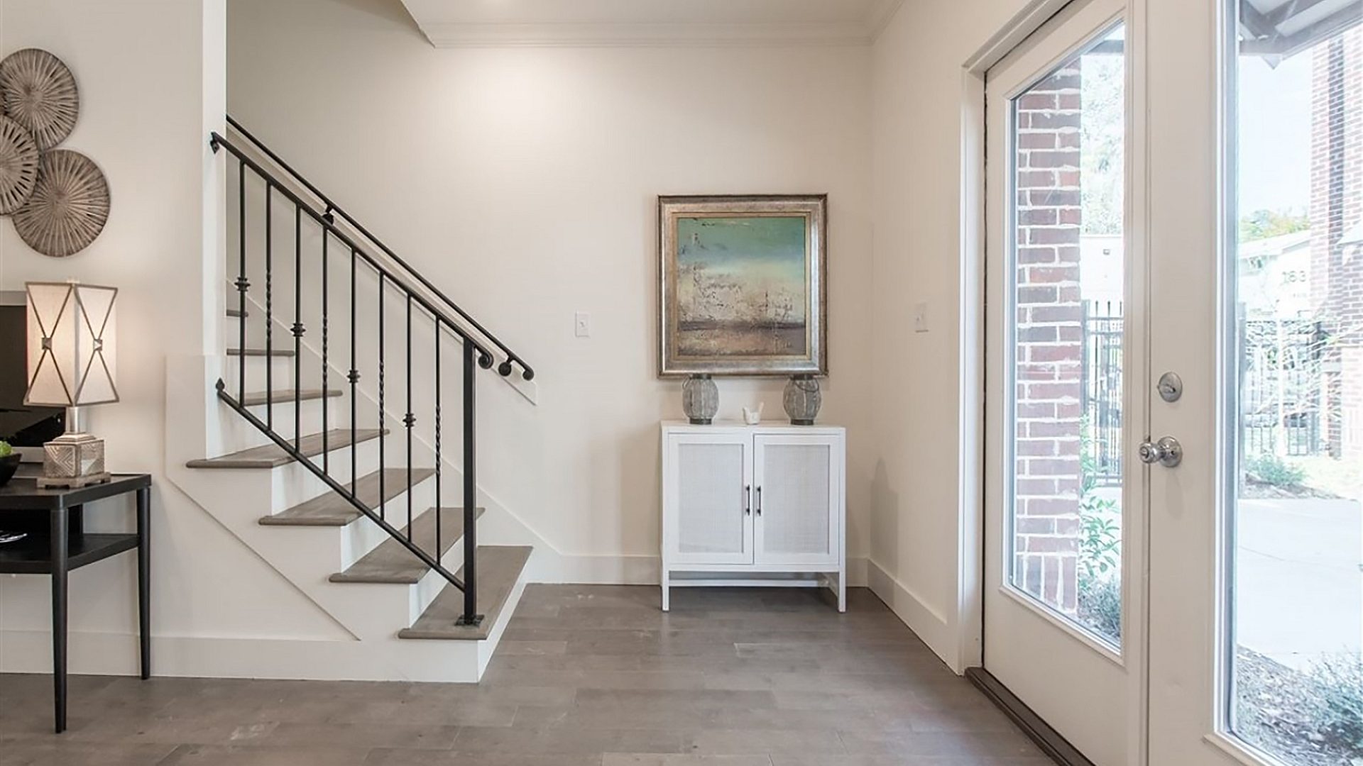 The entrance of a home, with stairs to the second floor on the left and the main doors to the right.