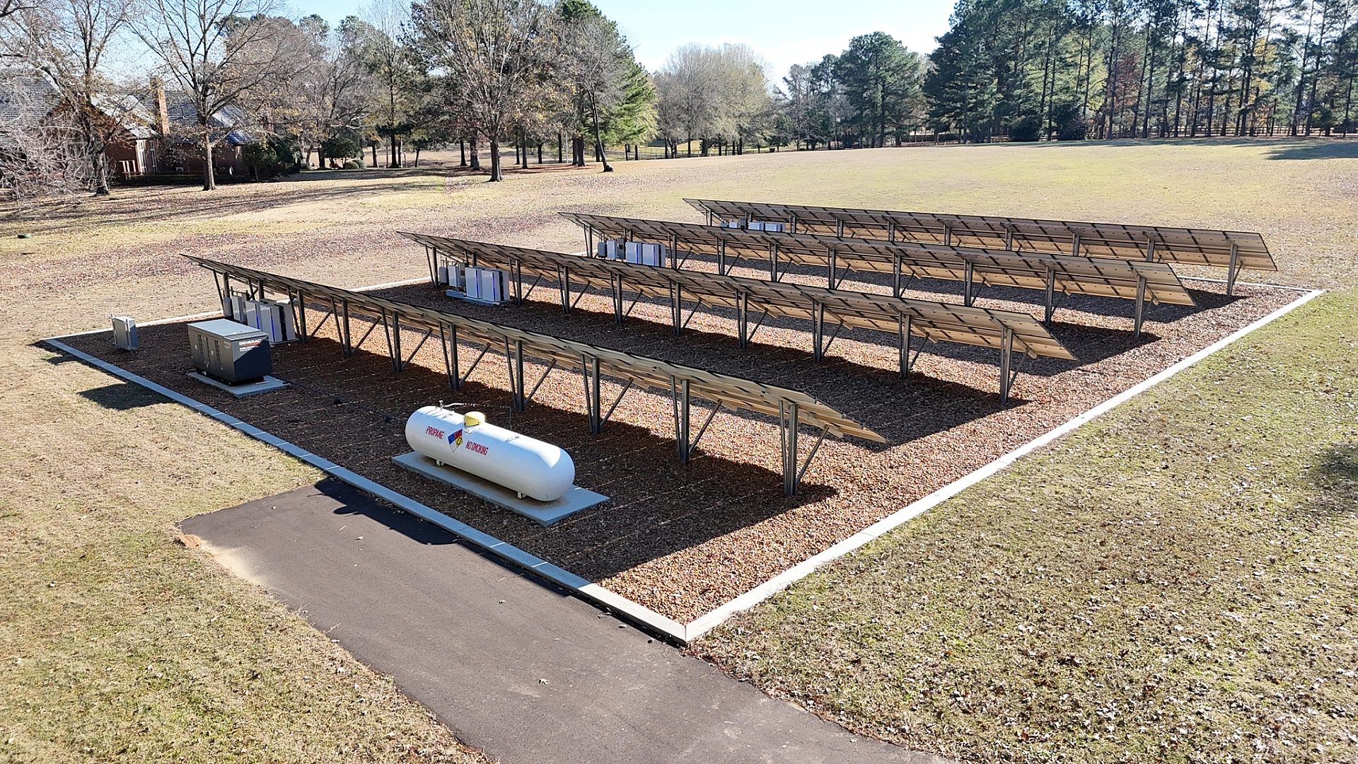 Four rows of solar panels in a yard