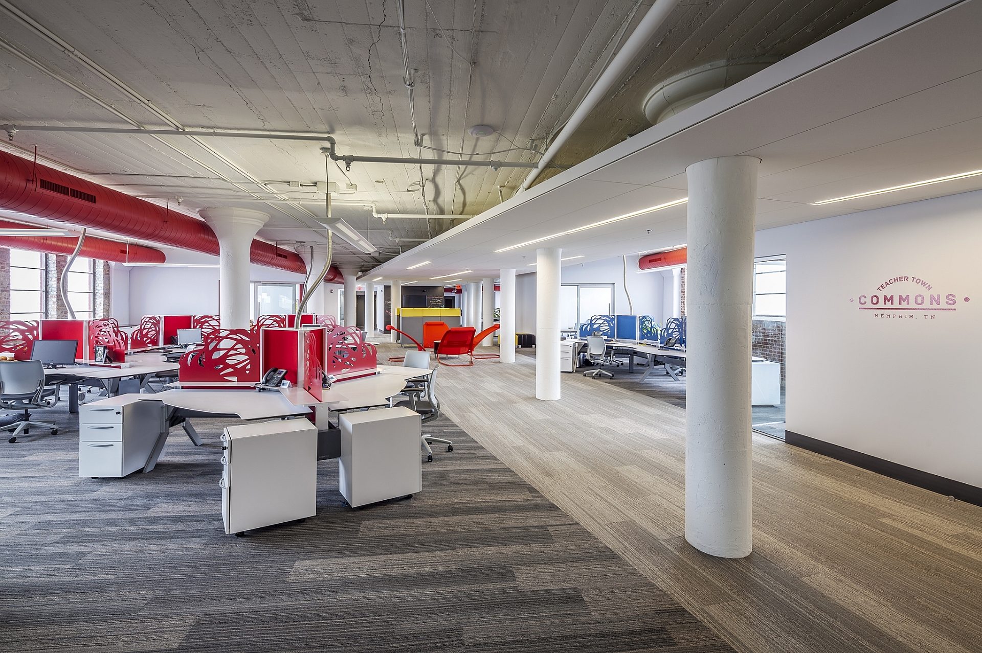 An open office space with white walls and red accents
