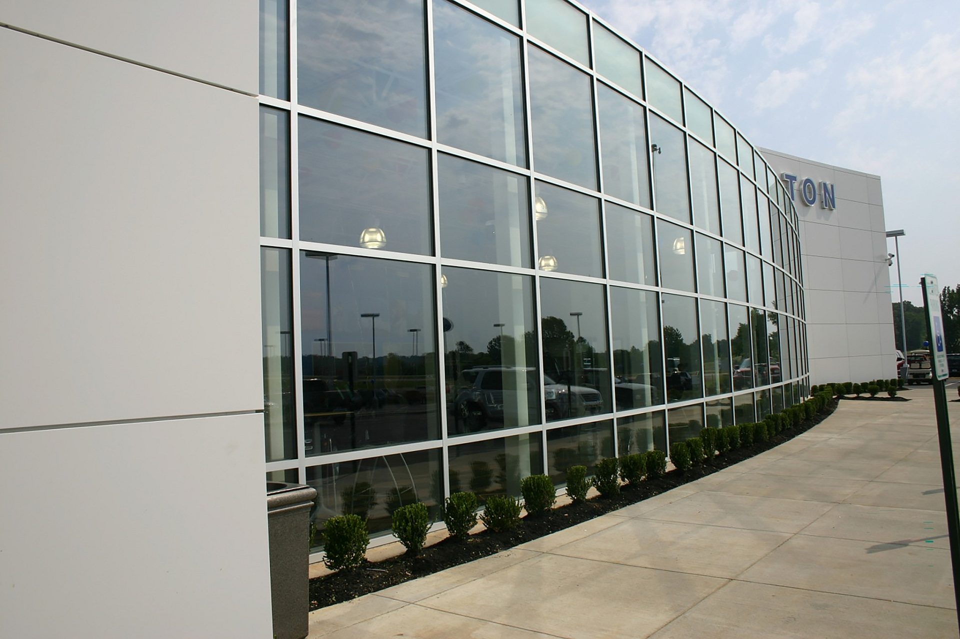 Floor to ceiling windows line the outside wall of a Ford dealership.