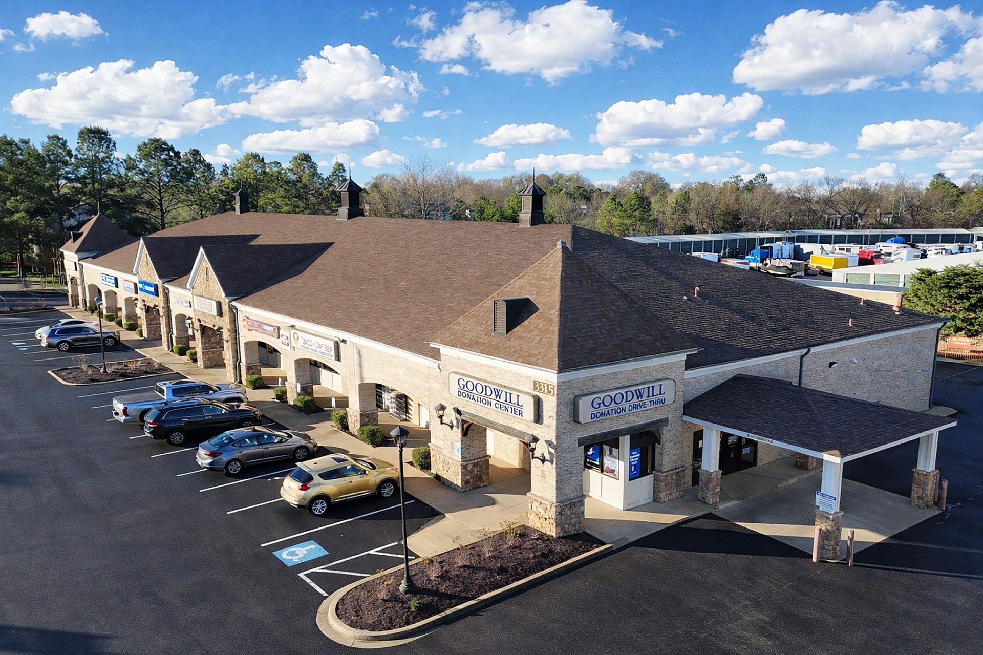 Aerial view of a shopping center with a drive through and cars in the parking lot
