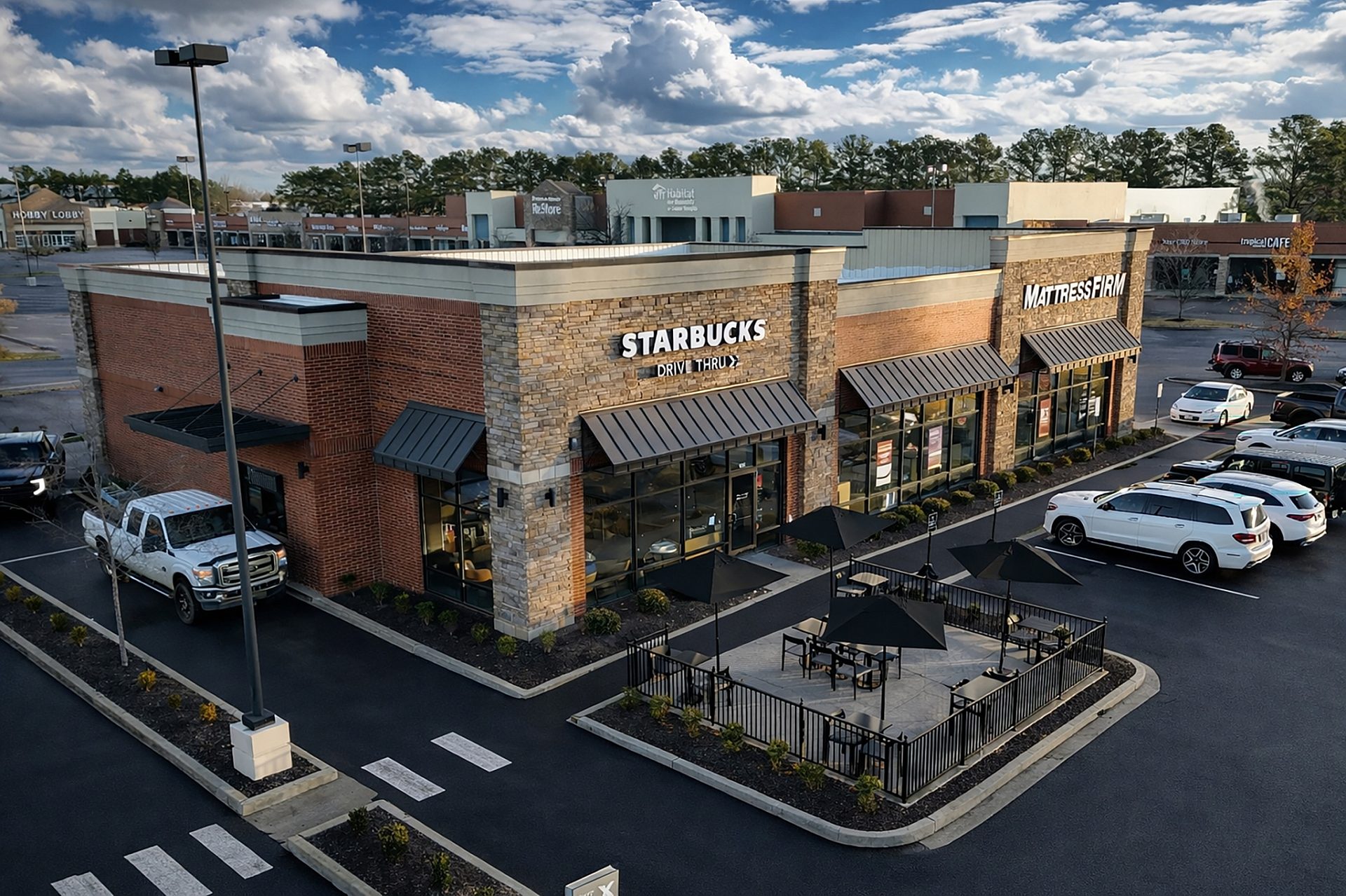Aerial view of a three bay shopping center in Collierville, TN with a patio and drive through.