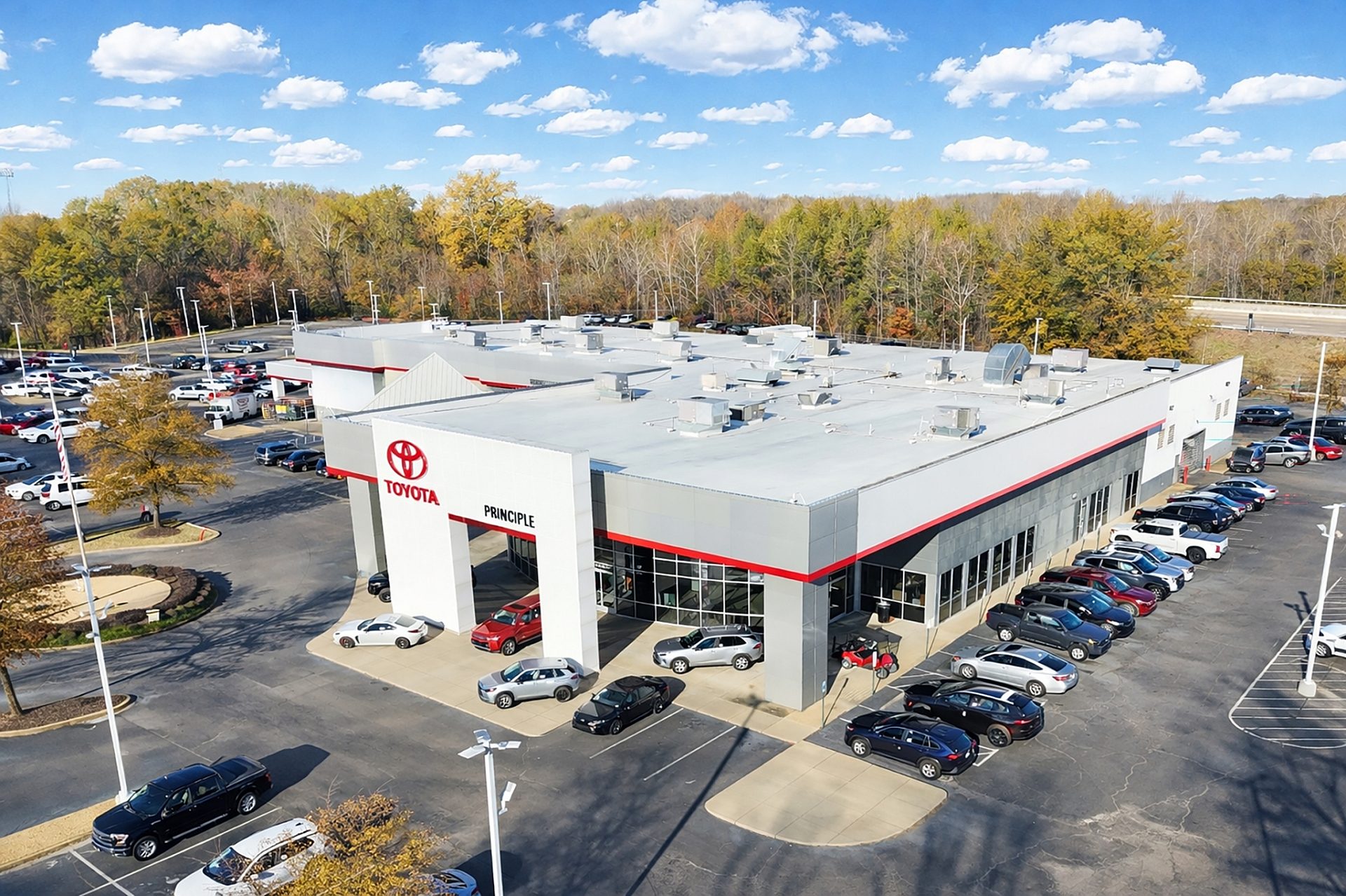 Aerial view of a Toyota car dealership with red accents on the trim
