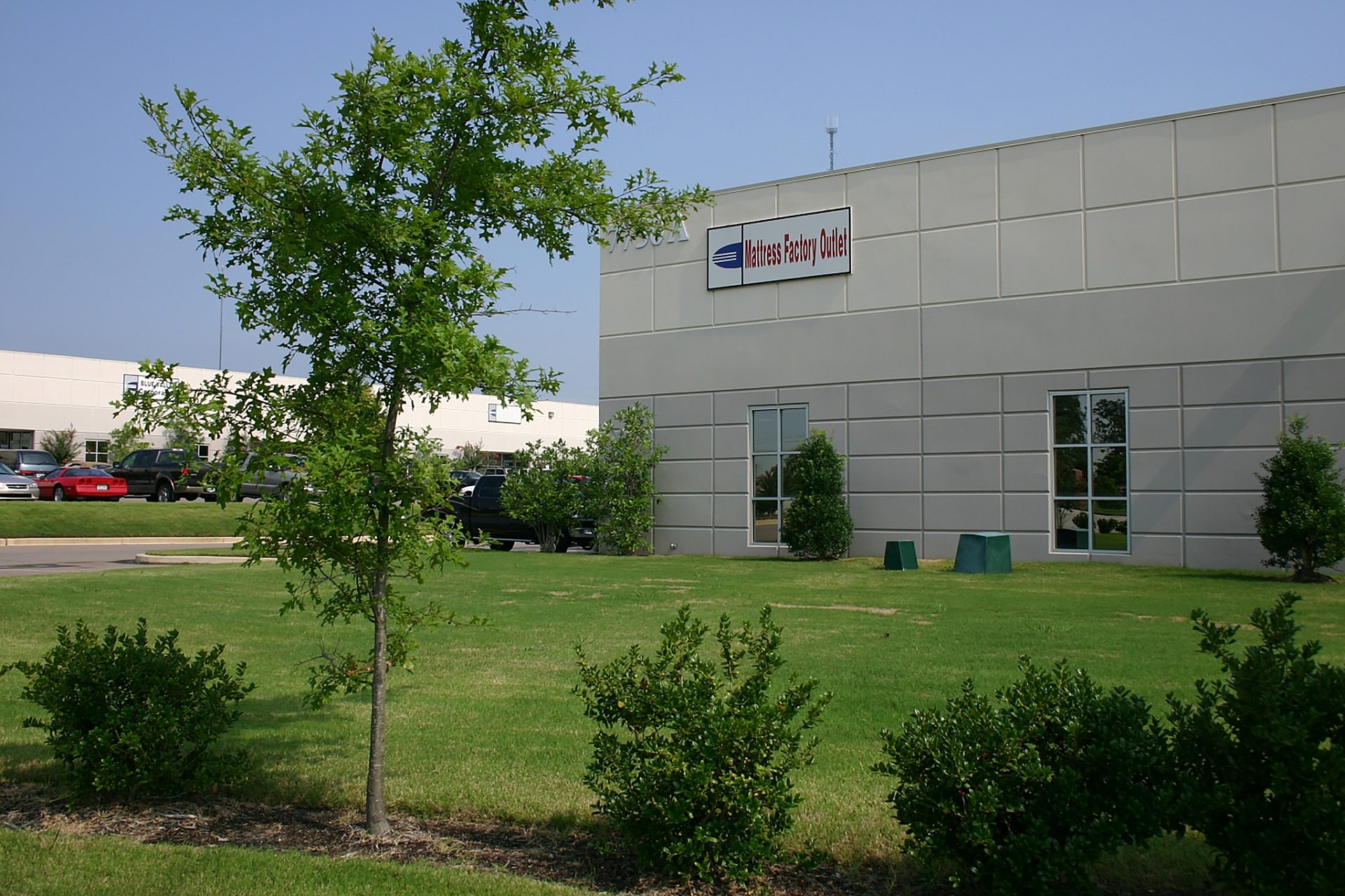 The exterior view of an office complex with a tree in the foreground