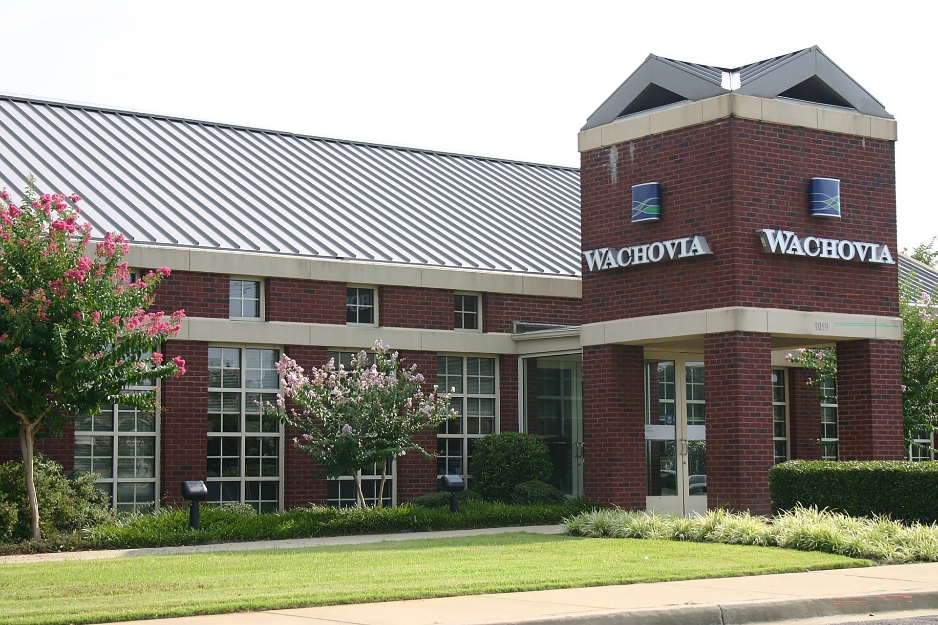 The exterior view of Wachovia Bank with a lawn and trees in front.