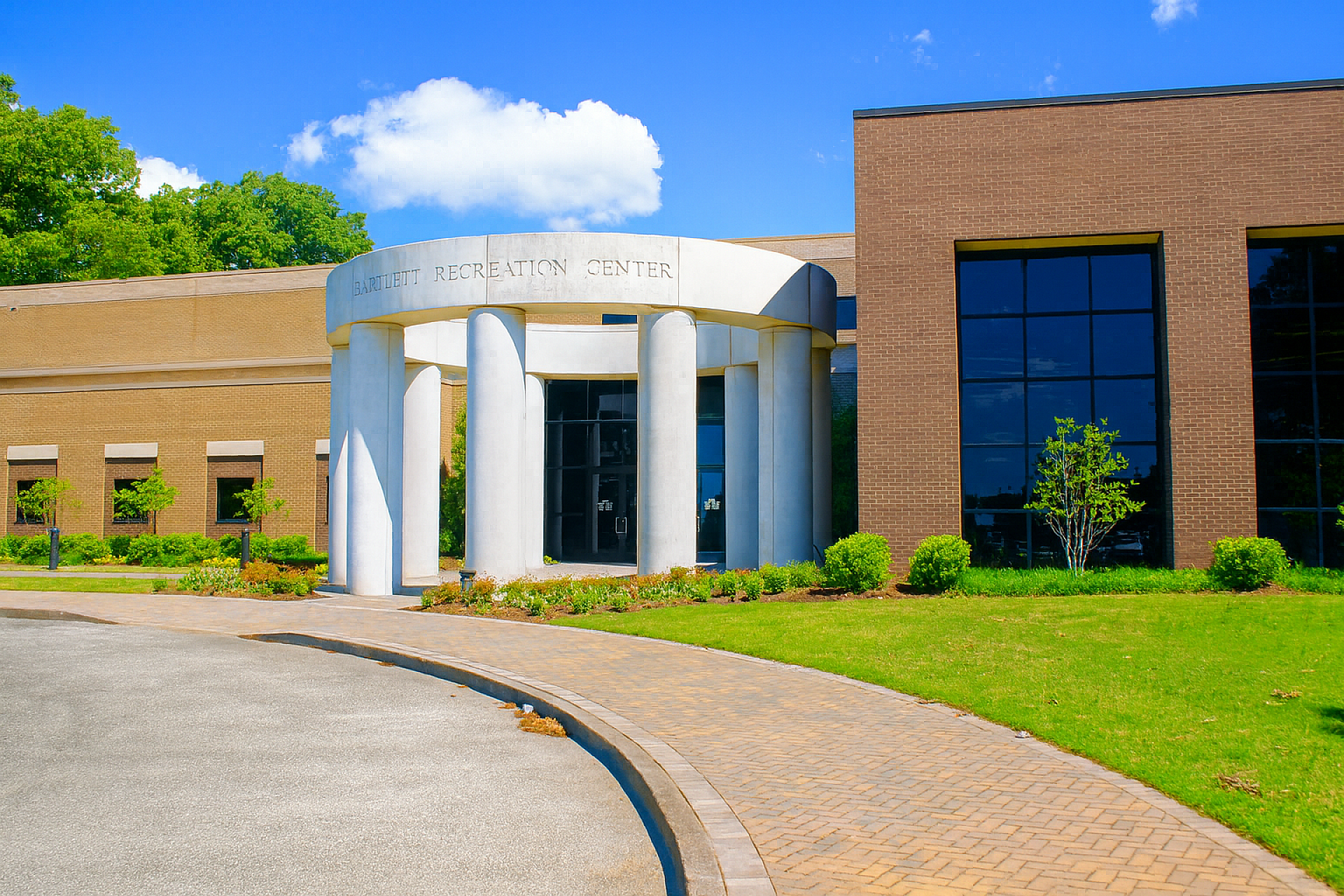 The entrance to a community rec center. A circular structure with columns supporting it is at the entrance with "Bartlett Recreation Center" written across the top.