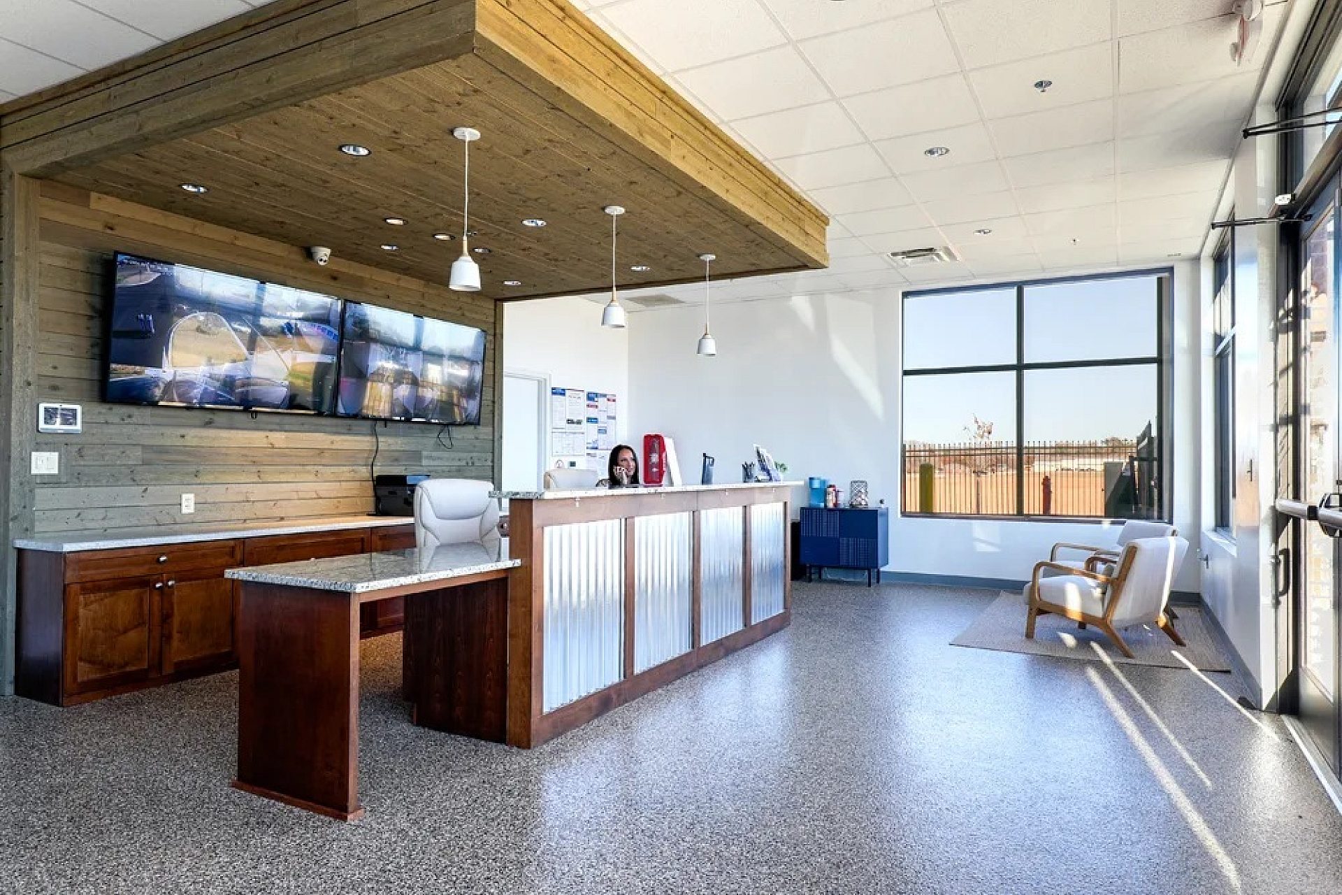 A waiting room with a kitchen island in the middle and two chairs in the waiting area.