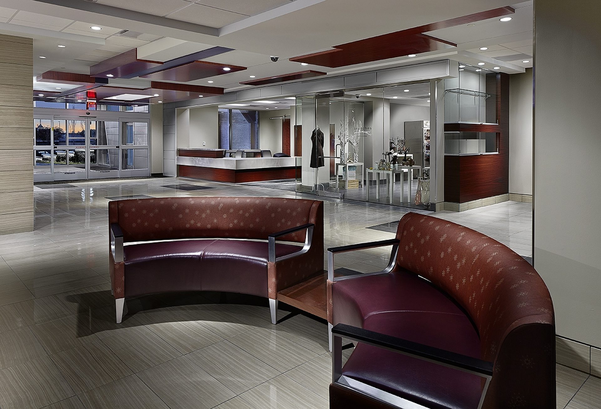 A hospital lobby with brown leather seating and a reception area in the background