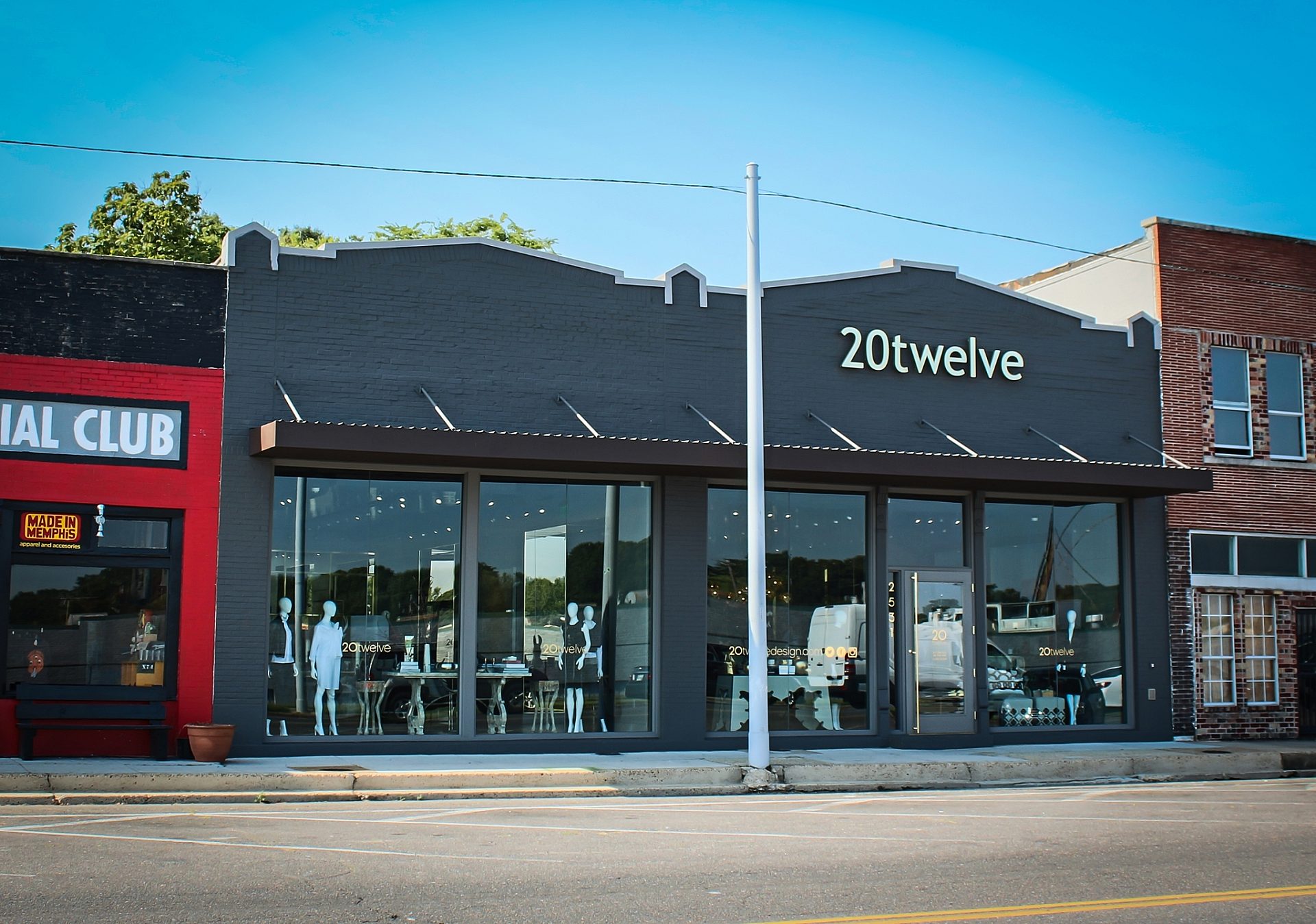 The exterior of a clothing store. Mannequins and retail items are on display in the window.