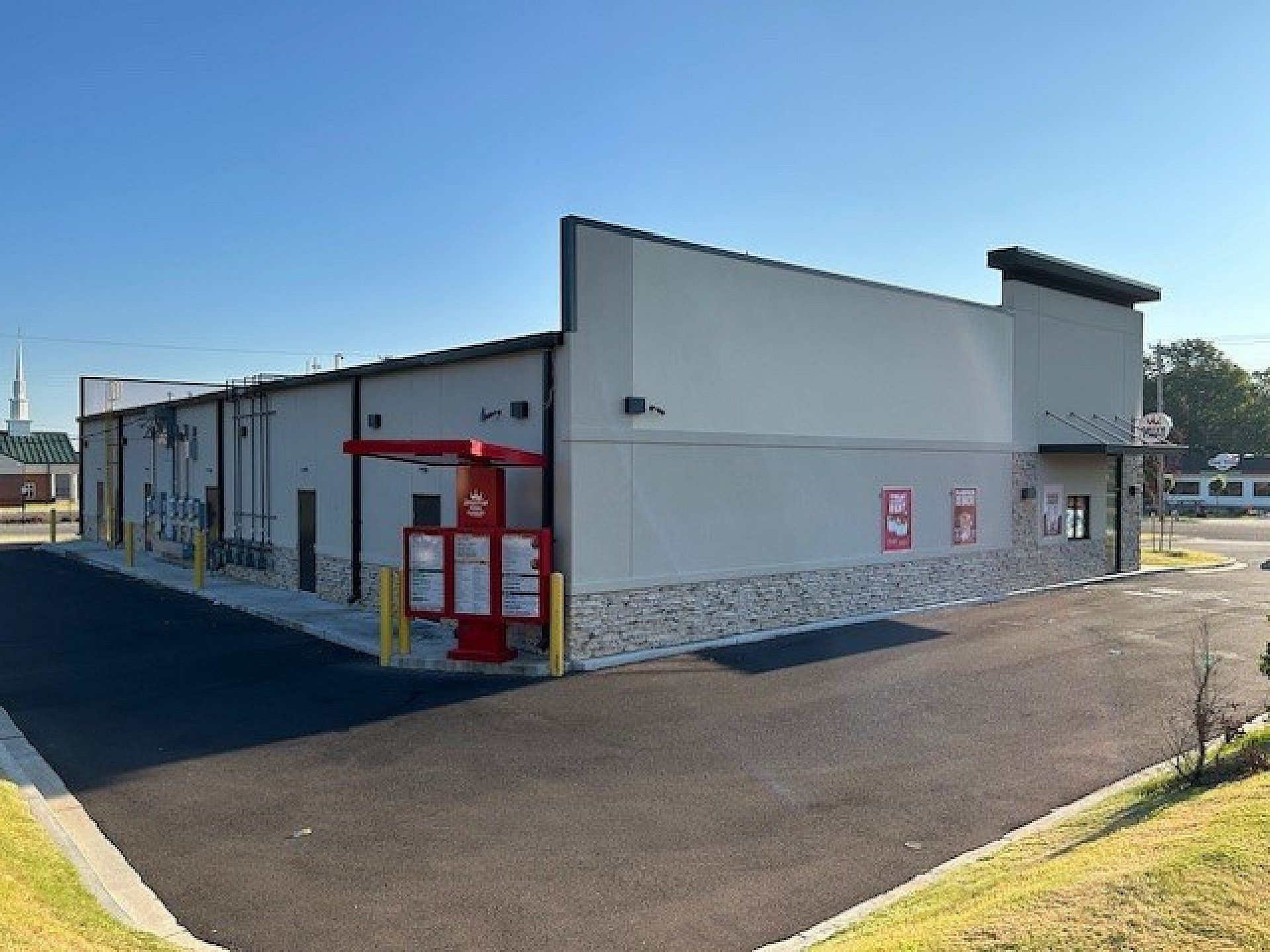 The rear view of a shopping center featuring a drive through.