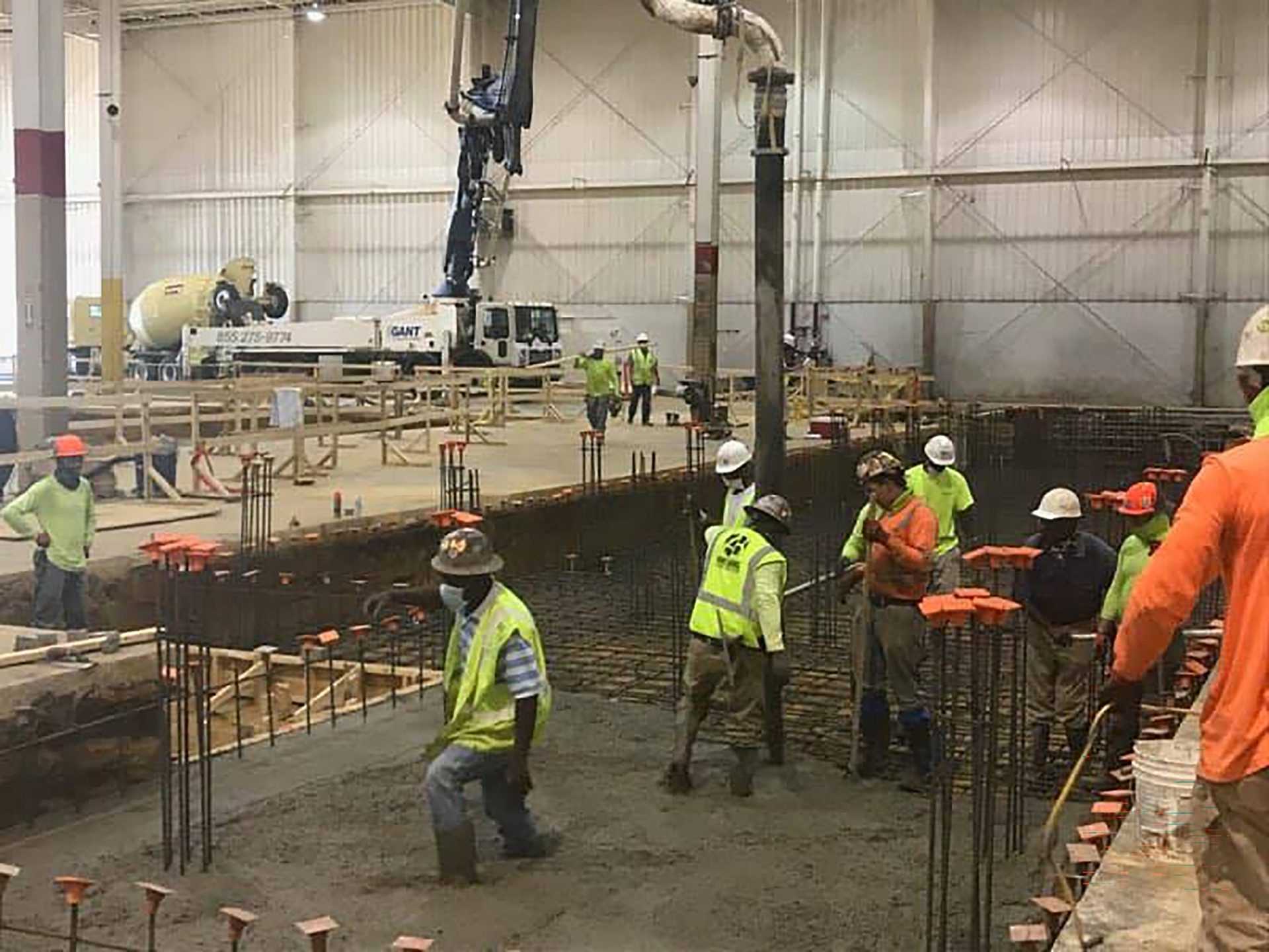 Several construction workers in a building under construction.