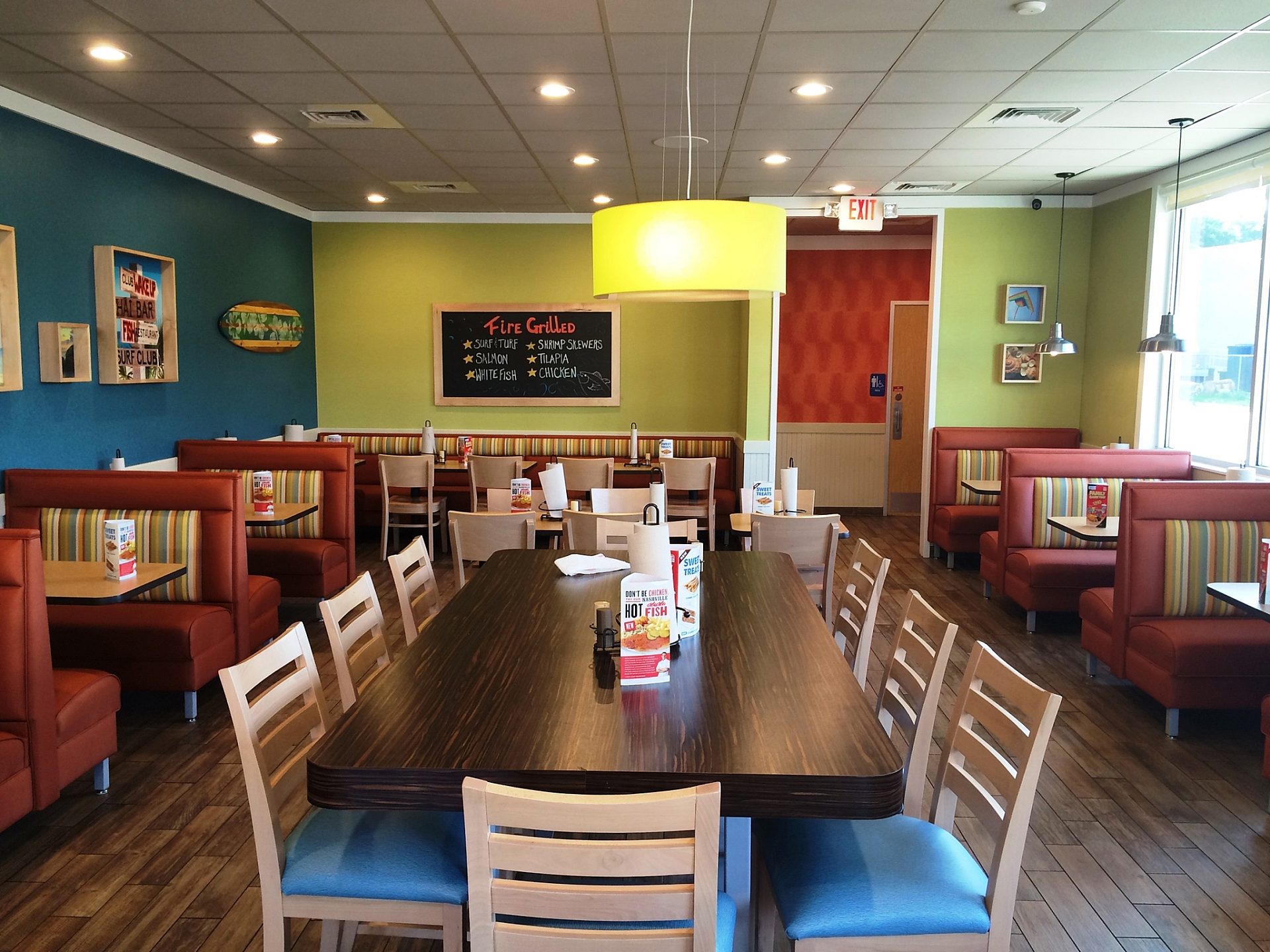 The dining room of a Captain D's with several booths lining the walls and tables in the middle.
