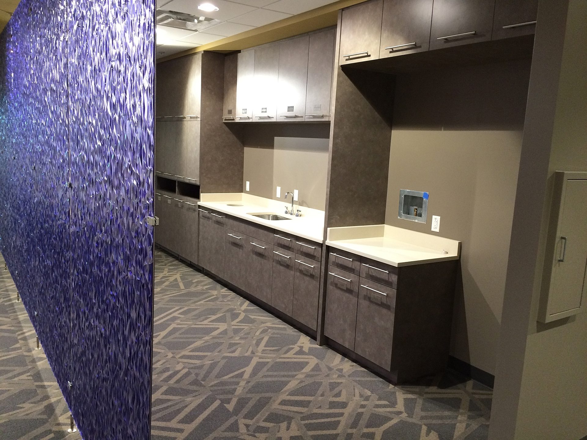 A wall lined with cabinets and a sink.