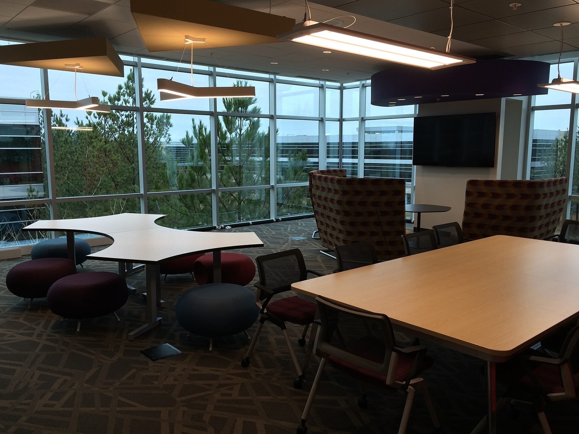 An open space in an office with two large tables and chairs.