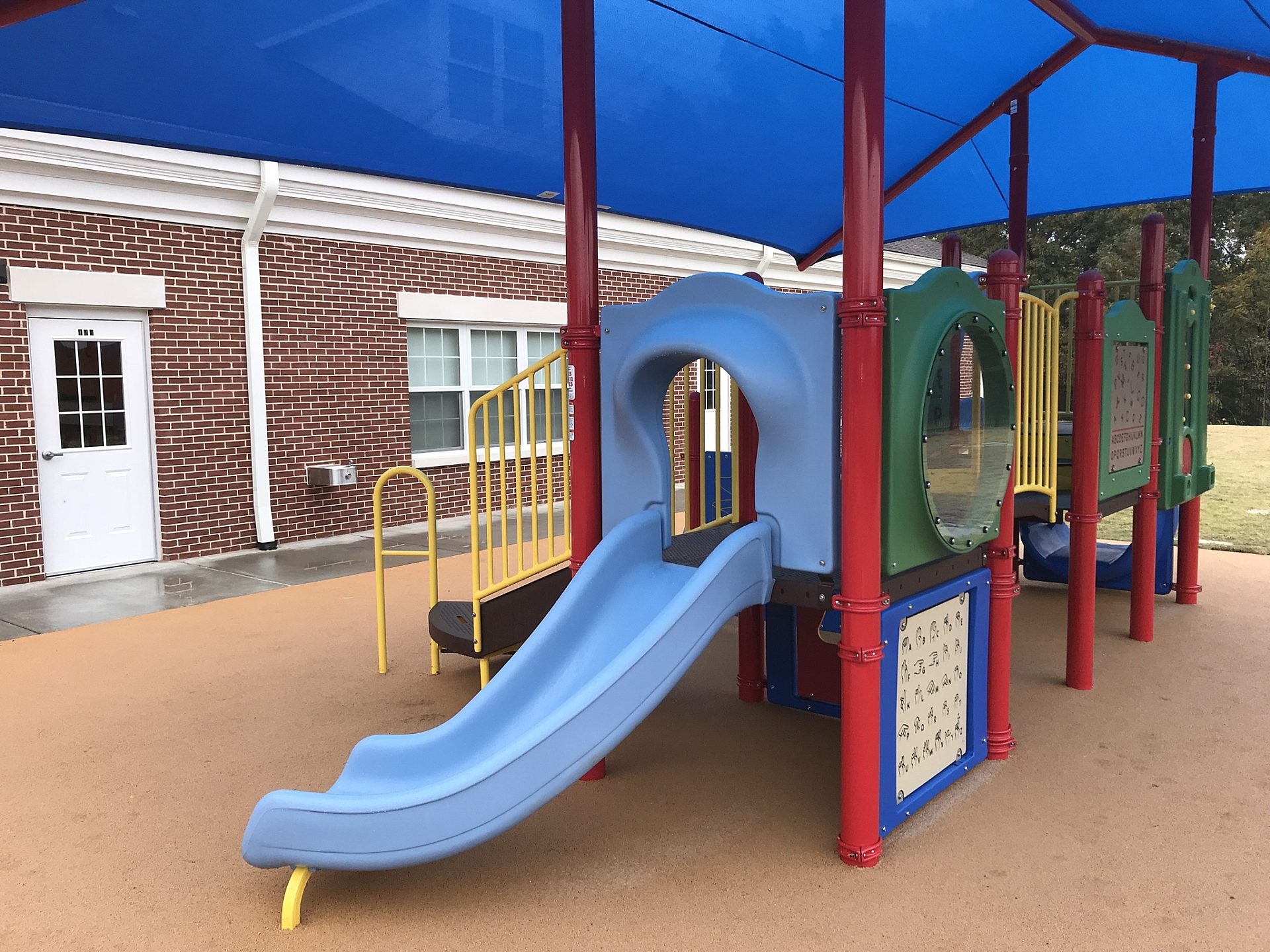 A blue slide on a school playground.