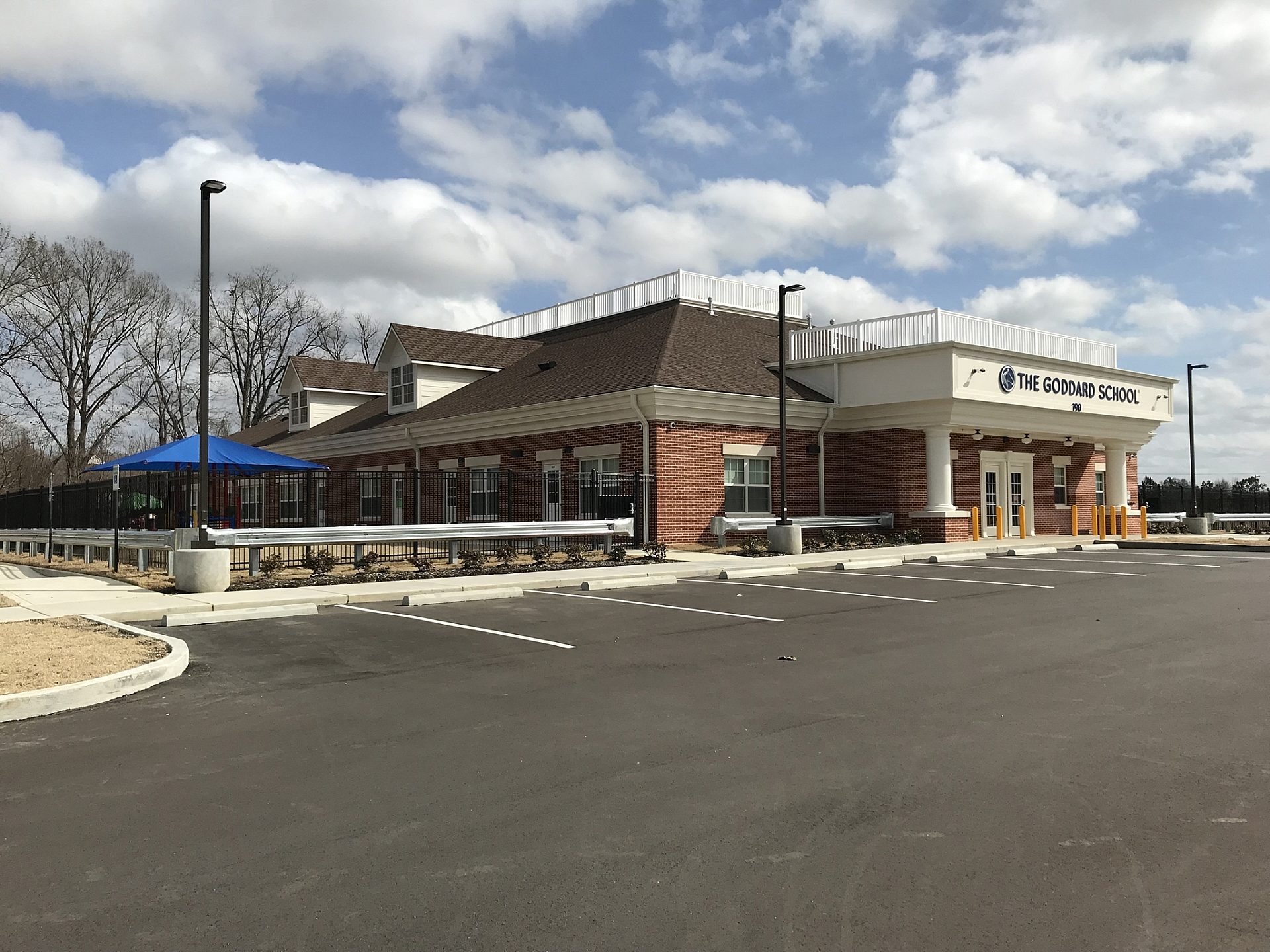 The entrance of a school with a playground to the left of it.