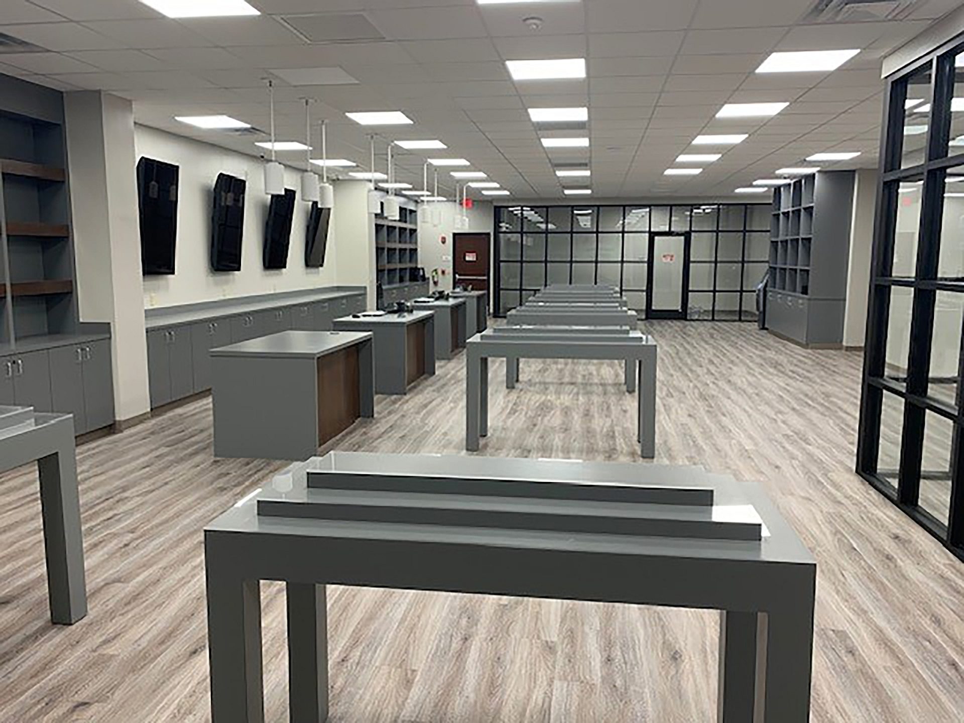 The interior of a store with tables down the middle and cabinets lining the walls.
