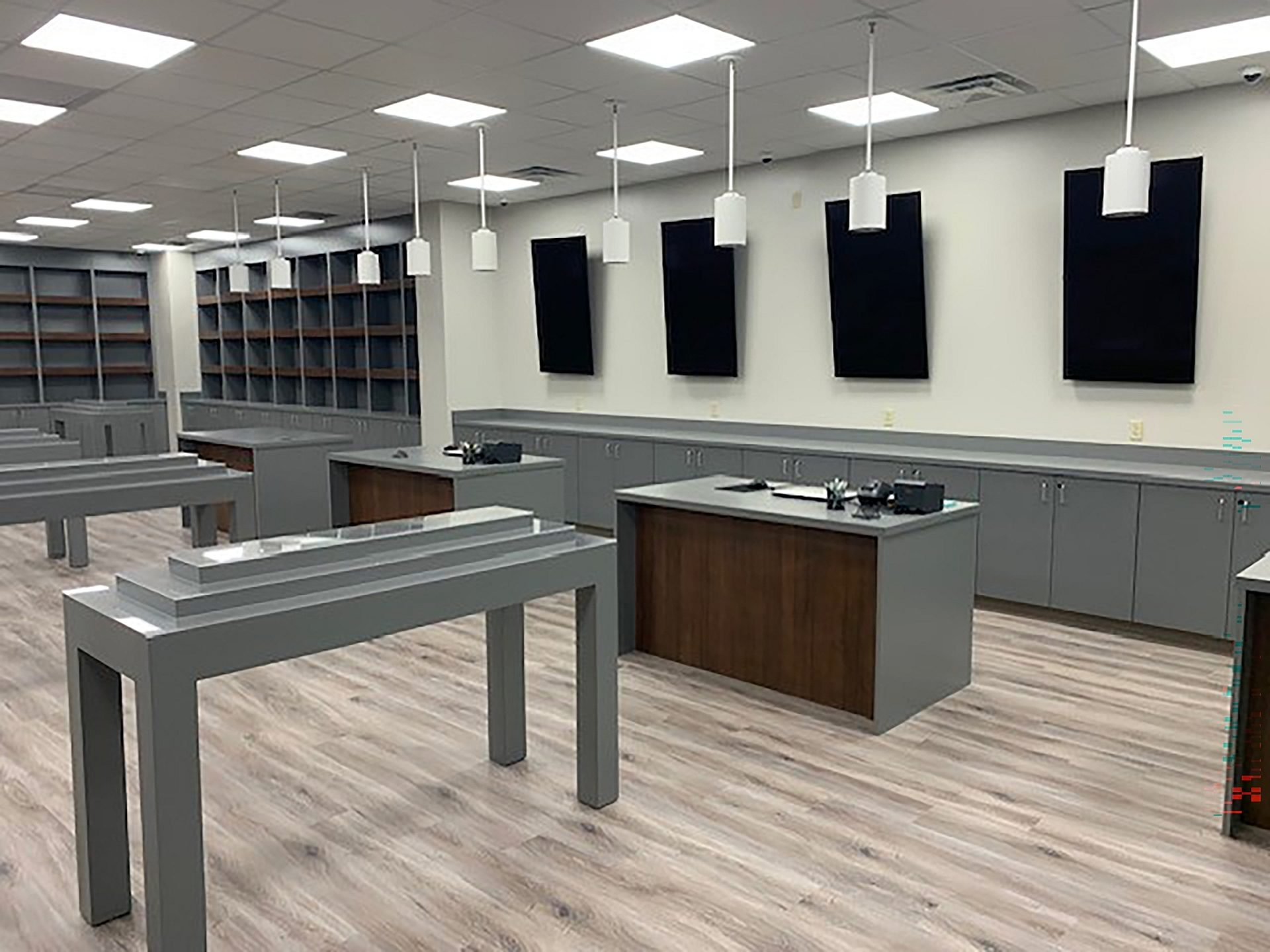 The interior of a dispensary. Cabinets and shelving line one wall with tables in the middle.