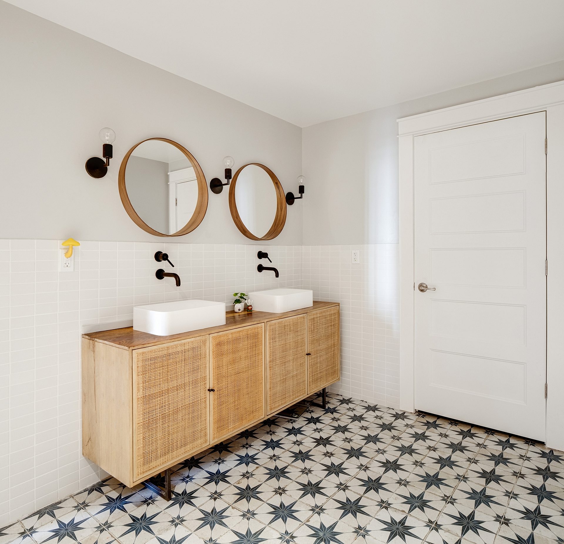 A modern bathroom with a double vanity and black and white tile