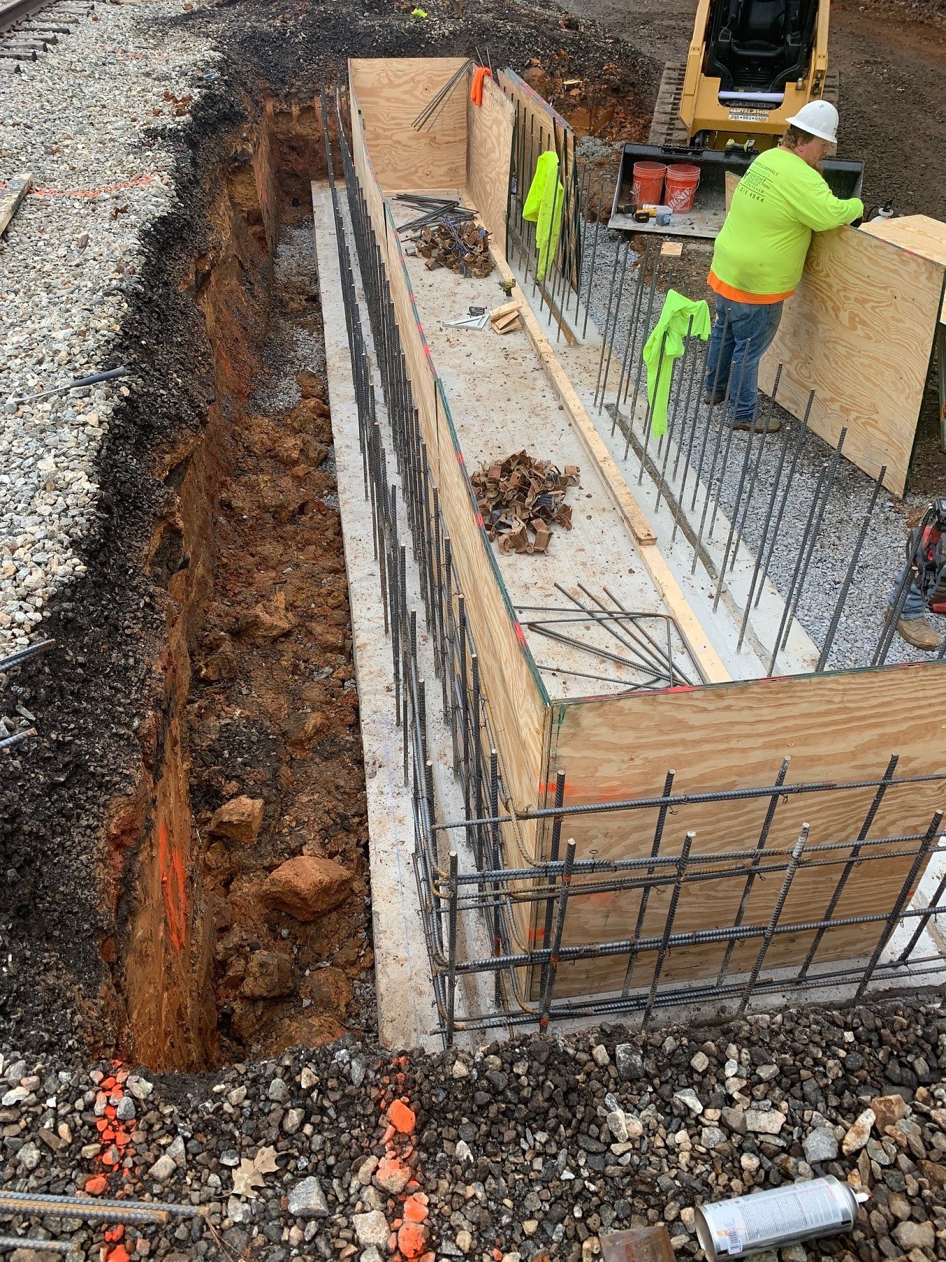 Construction worker installs plywood for a concrete foundation