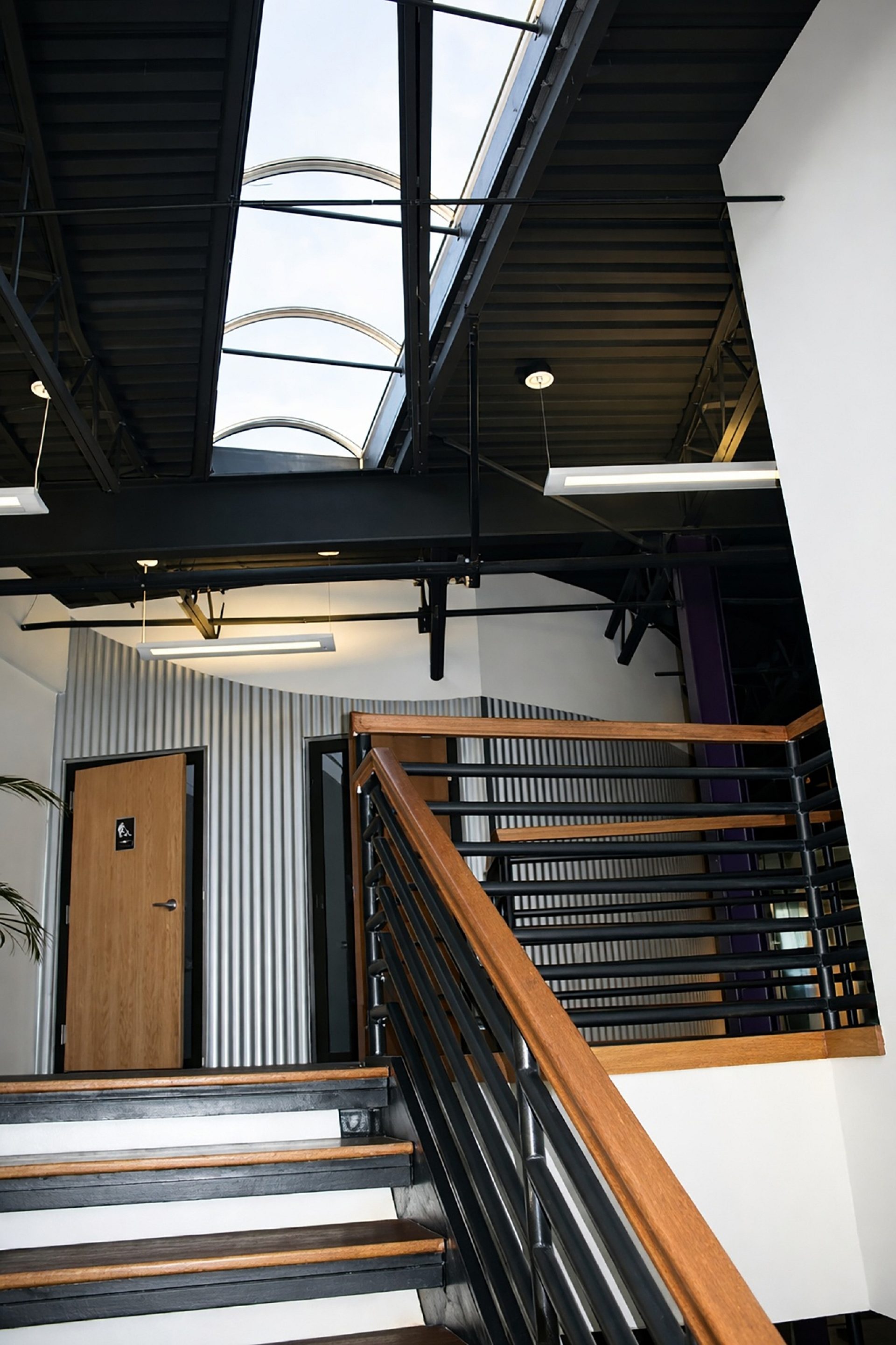 A stairwell leading up to a bathroom with a skylight in the ceiling.