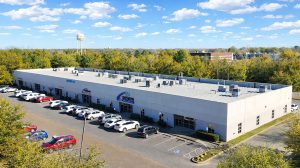 Aerial view of office buildings surrounded by trees with a water tower in the distance