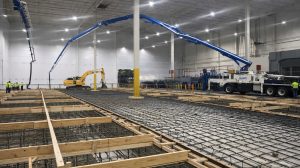 The interior of an industrial building under construction with the foundation under way.