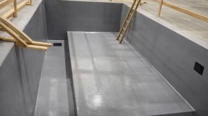 A cut-out pit in a construction zone with a ladder leading into it.