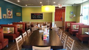 The dining room of a Captain D's with several booths lining the walls and tables in the middle.