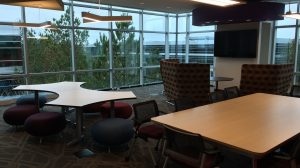 An open space in an office with two large tables and chairs.