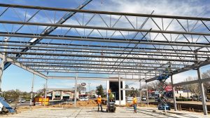 A construction site for a shopping center with construction workers in the middle of it.
