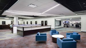 An office open space with a desk facing chairs and a table.