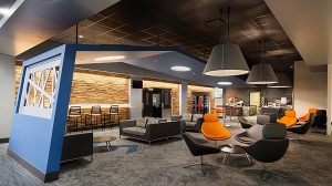 A modern lounge area in an office with several chairs, tables and couches.