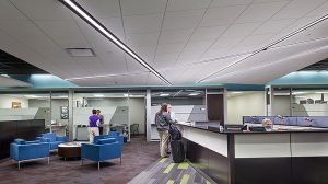A desk faces the open area of an office with chairs and a table in front of it.