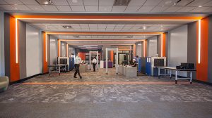 An open office space with a few desks lining the walls and people walking throughout.