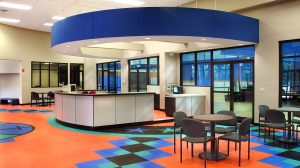 A lounge area with several tables and chairs in an athletic center.