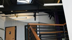 A stairwell leading up to a bathroom with a skylight in the ceiling.