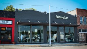 The exterior of a clothing store. Mannequins and retail items are on display in the window.